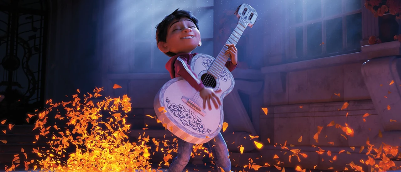 Miguel toca una guitarra blanca entre pétalos de cempasúchil en Coco.