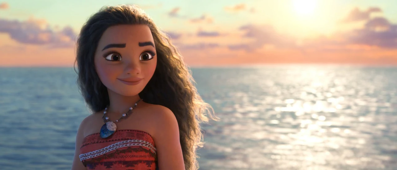 Moana frente al océano al atardecer, en la película animada de 2016.